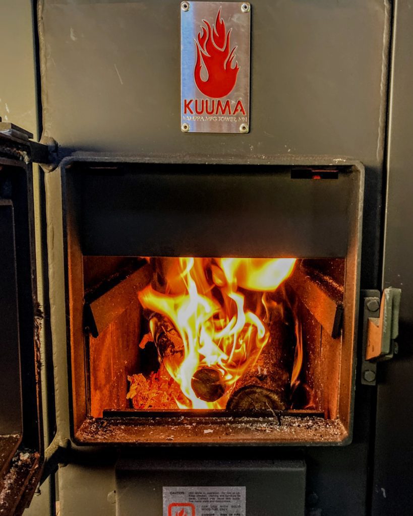 Reaching sauna temperature with a Kuuma wood-fired stove with a fire in it.